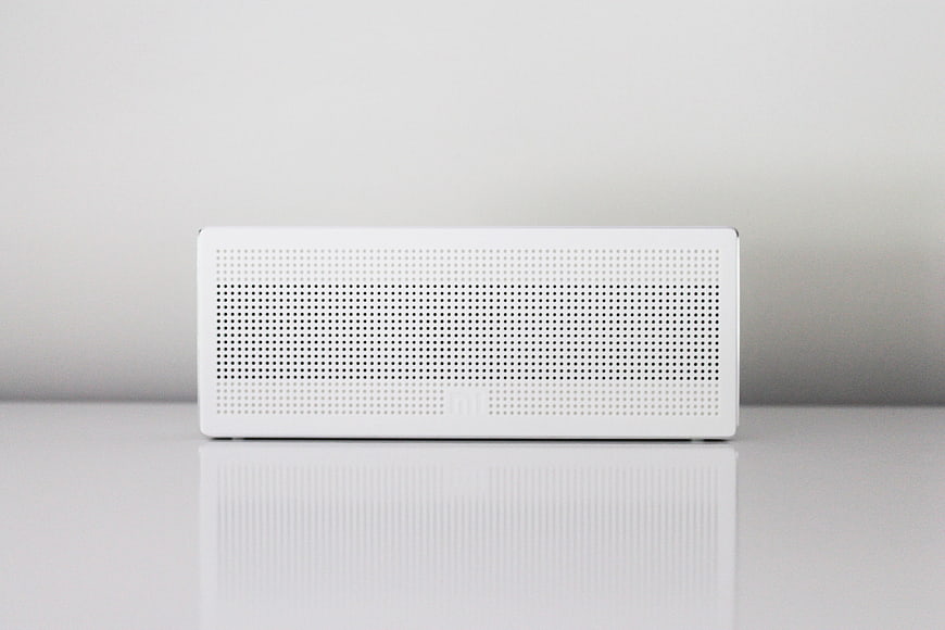 Minimalist White Bluetooth Speaker on Reflective Surface