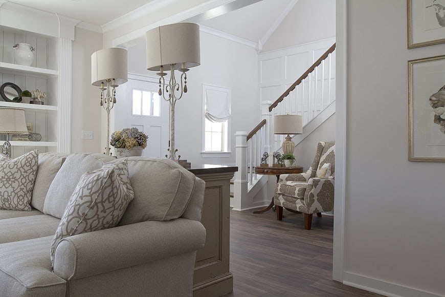 Bright white living room interior with beige sofa and staircase
