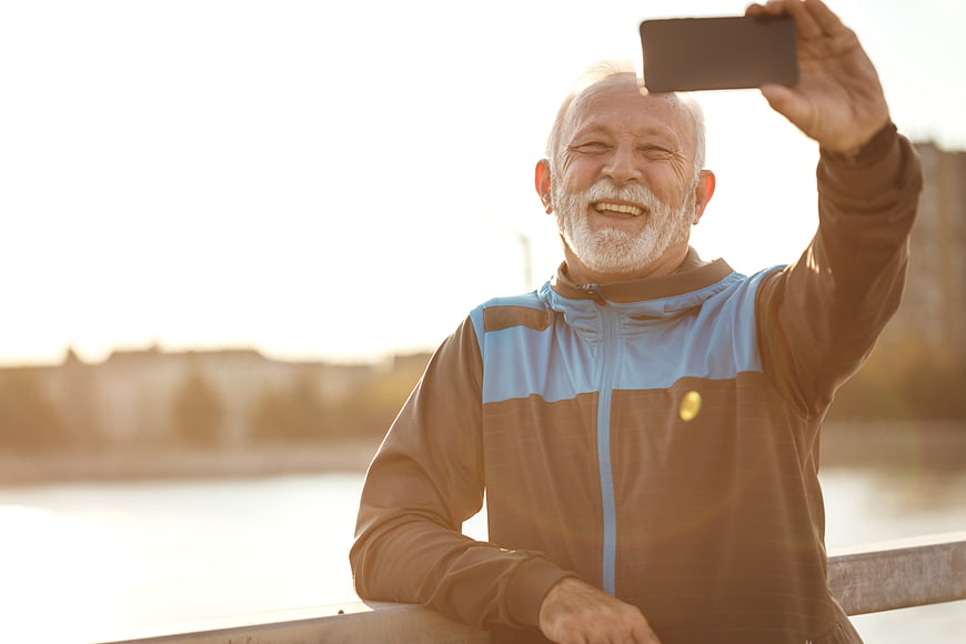 Happy Senior Man Taking Selfie Outdoors in Sportswear