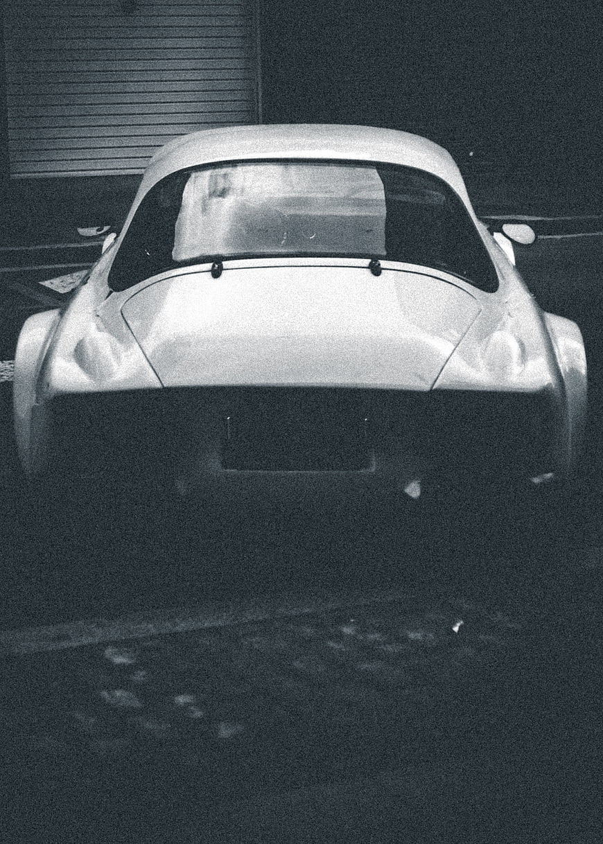 Rear view of vintage classic car in grainy black and white
