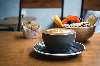 Cappuccino with Latte Art and Granola Bowl on Wooden Table