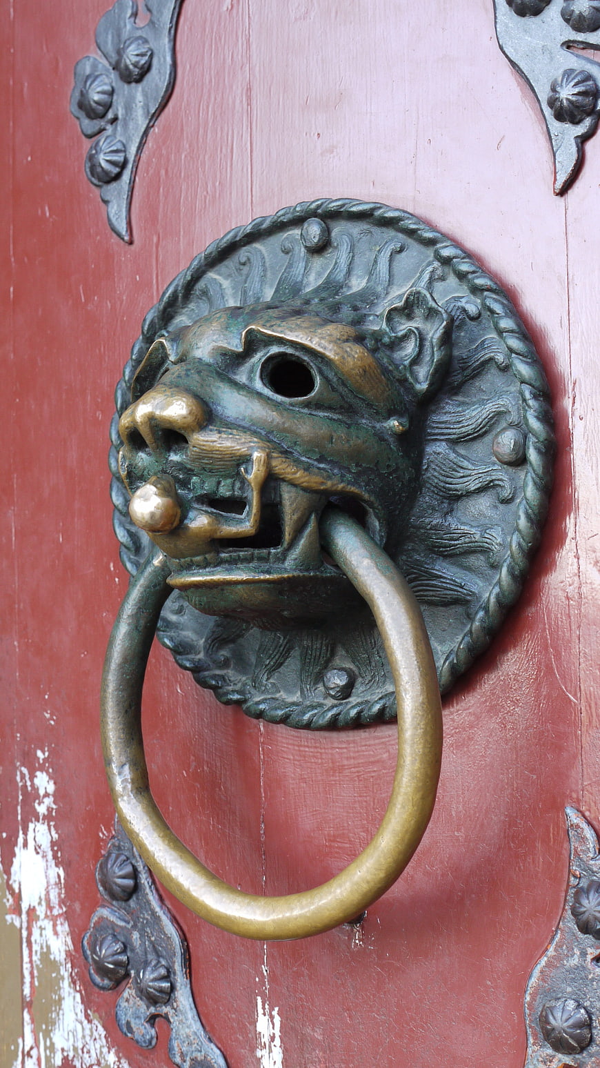 Traditional Chinese Lion Head Door Knocker on Red Wooden Door