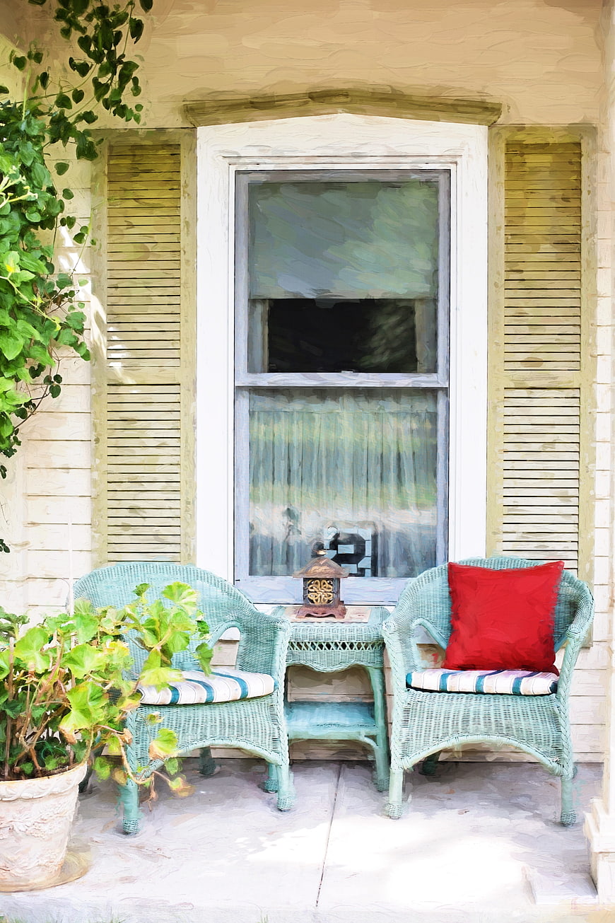 Cozy Country Porch With Wicker Chairs And Red Pillow