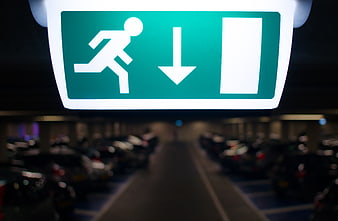 Illuminated Green Emergency Exit Sign in Parking Garage