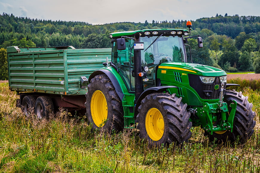 Green John Deere Tractor with Trailer in Field