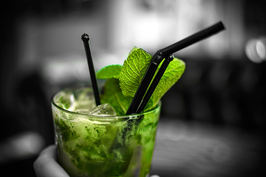 Mojito cocktail with mint garnish and black straws