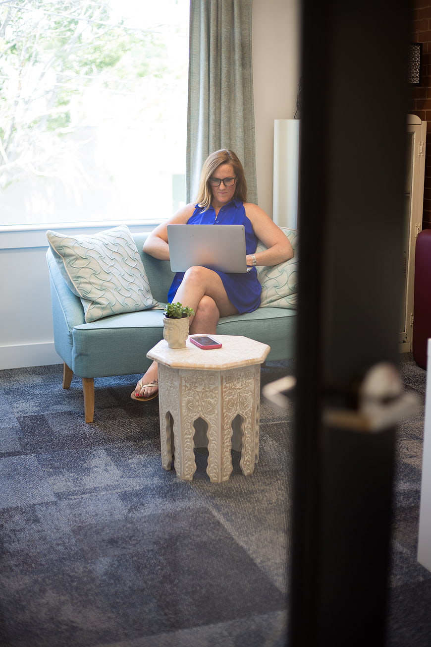 Woman working on laptop in modern office lounge