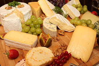 Gourmet cheese platter with grapes, figs, and walnuts on wood