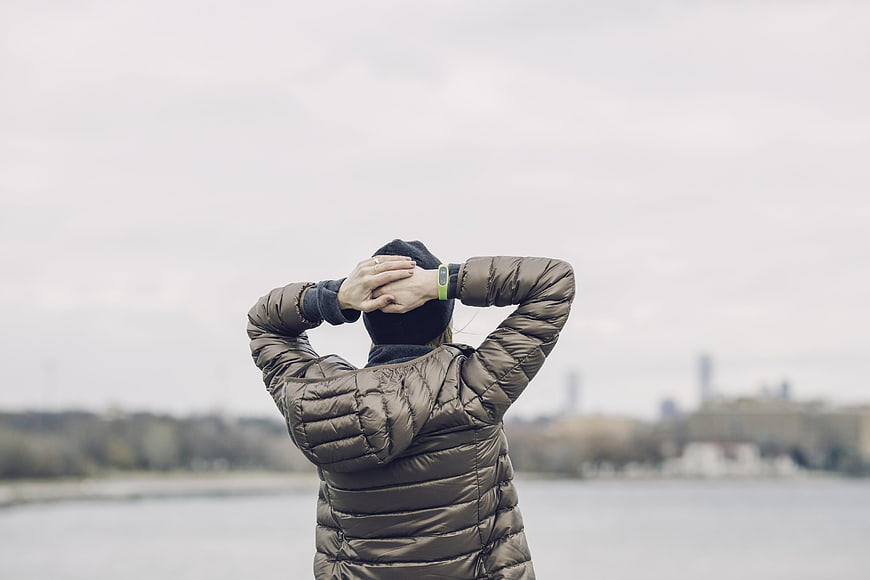 Woman in Puffer Jacket Looking at City Skyline