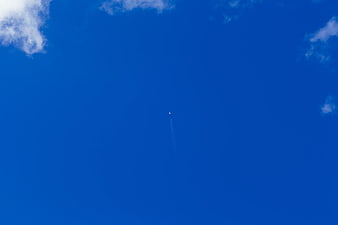 Minimalist Blue Sky with Distant Airplane Contrail