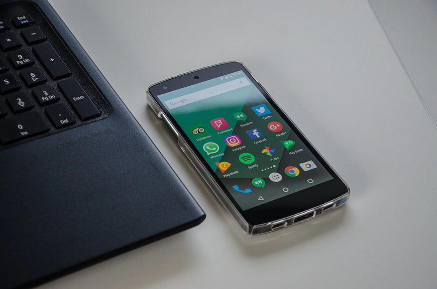 Black Android Smartphone Next to Laptop Keyboard