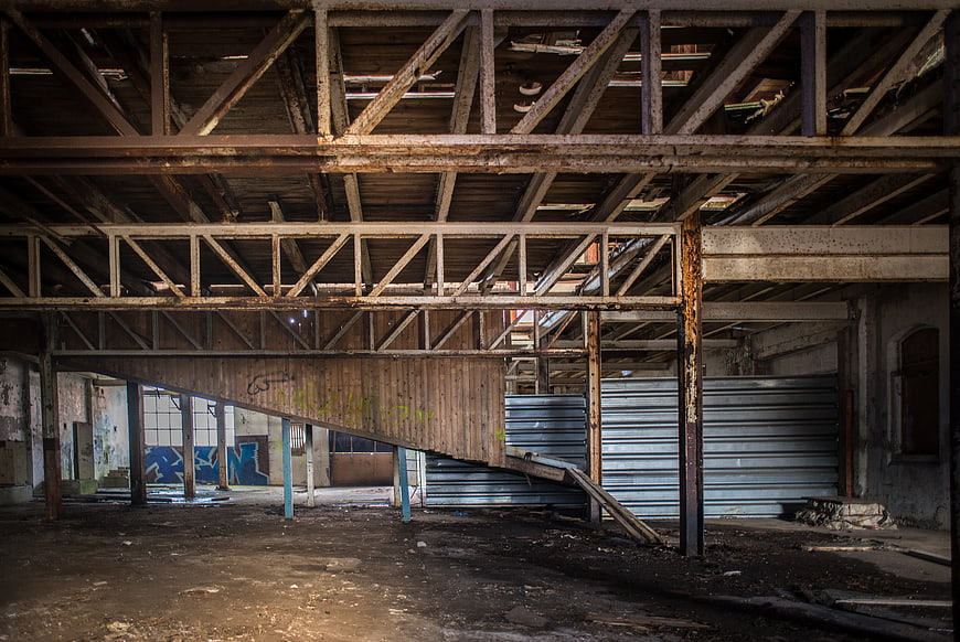 Abandoned industrial interior with rusty steel beams and decay