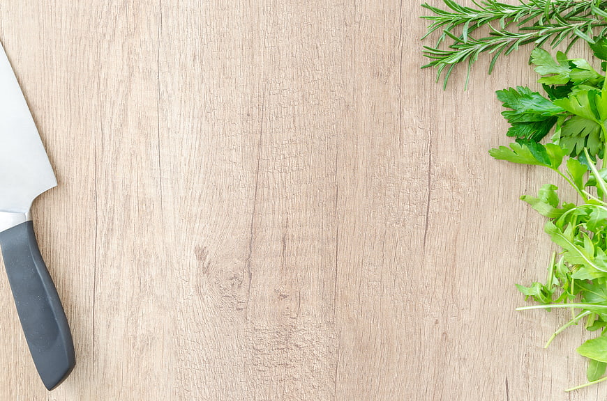 Fresh Herbs and Chef Knife on Wooden Cutting Board Background