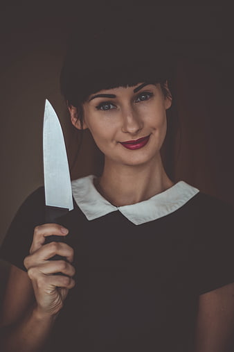 Portrait of woman holding kitchen knife with smile
