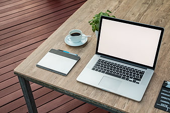 Laptop workspace mockup with coffee and notepad on wooden table