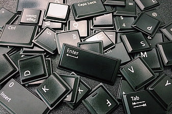 Scattered Black Computer Keyboard Keys on Dark Surface