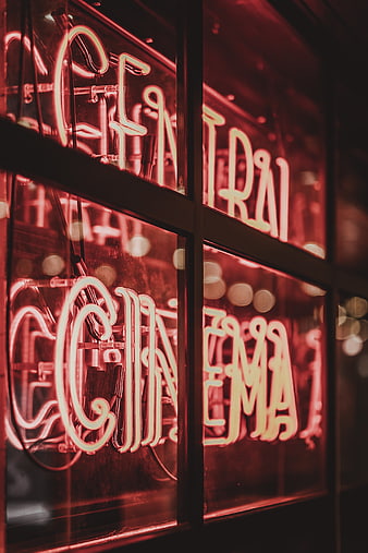 Red Neon Cinema Sign in Window at Night