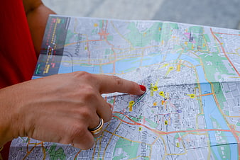 Woman pointing at city map with red nail polish