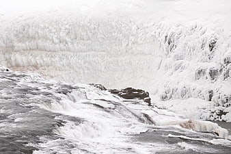 Frozen waterfall cascading over ice-covered cliffs in winter