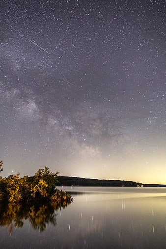 Milky Way Galaxy Over Calm Lake with Meteor Trails