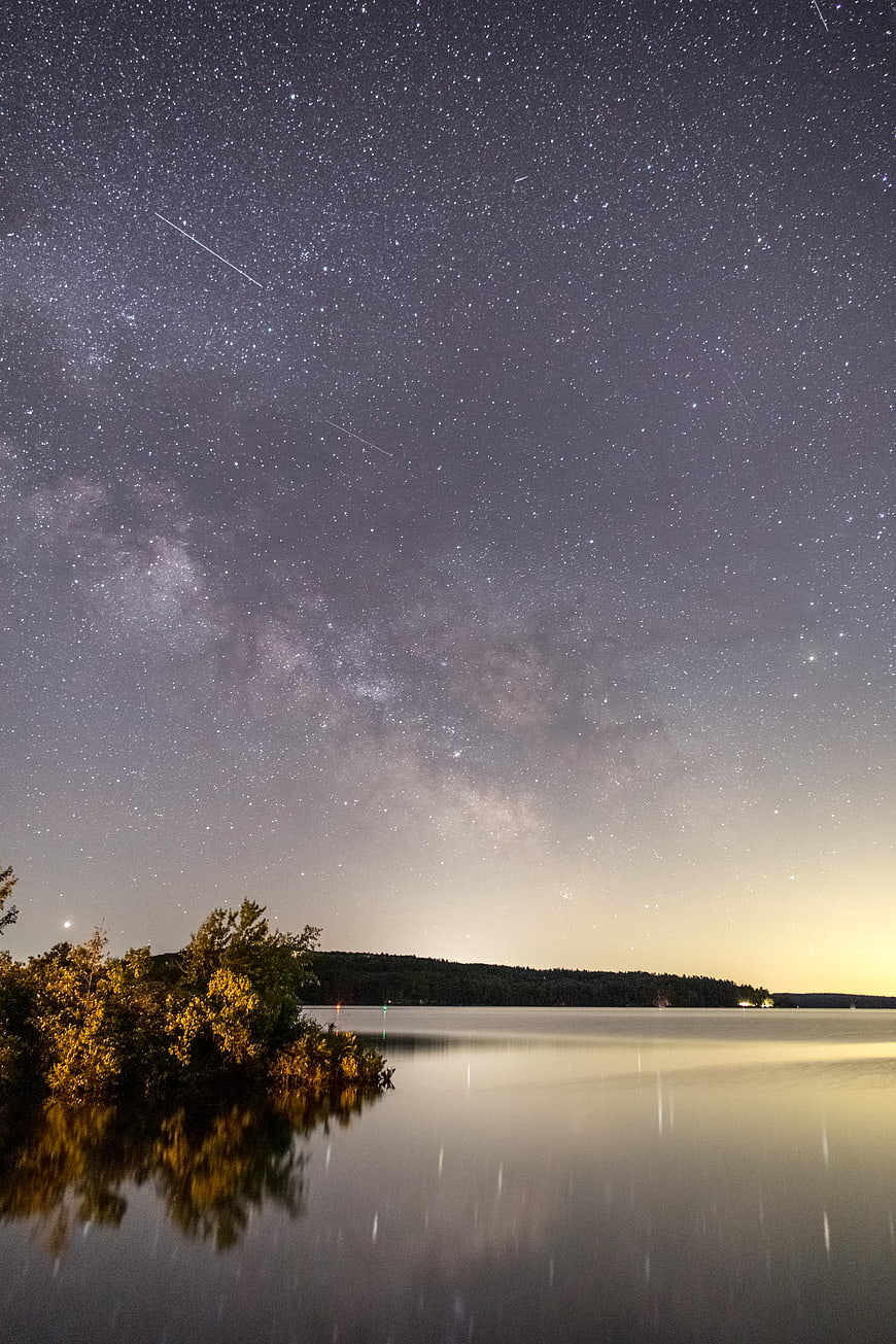 Milky Way Galaxy Over Calm Lake with Meteor Trails
