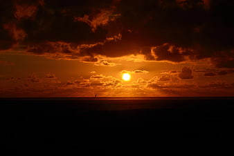 Dramatic Orange Sunset Over Dark Ocean Horizon