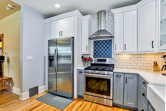 Modern kitchen with stainless steel appliances and blue tile backsplash