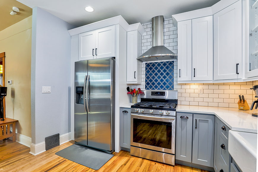 Modern kitchen with stainless steel appliances and blue tile backsplash