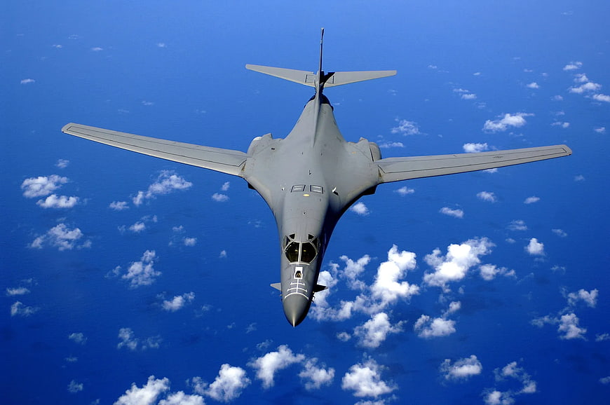 Military Bomber Jet Flying Over Blue Sky with Clouds
