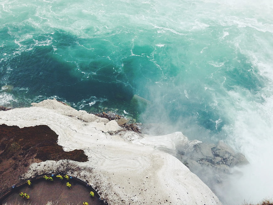 Aerial View of Turquoise Waterfall and Cliff Edge
