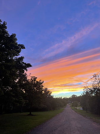 Vibrant Sunset Sky Over Rural Gravel Road