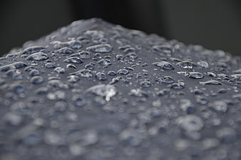 Close-up of water droplets on a dark textured surface