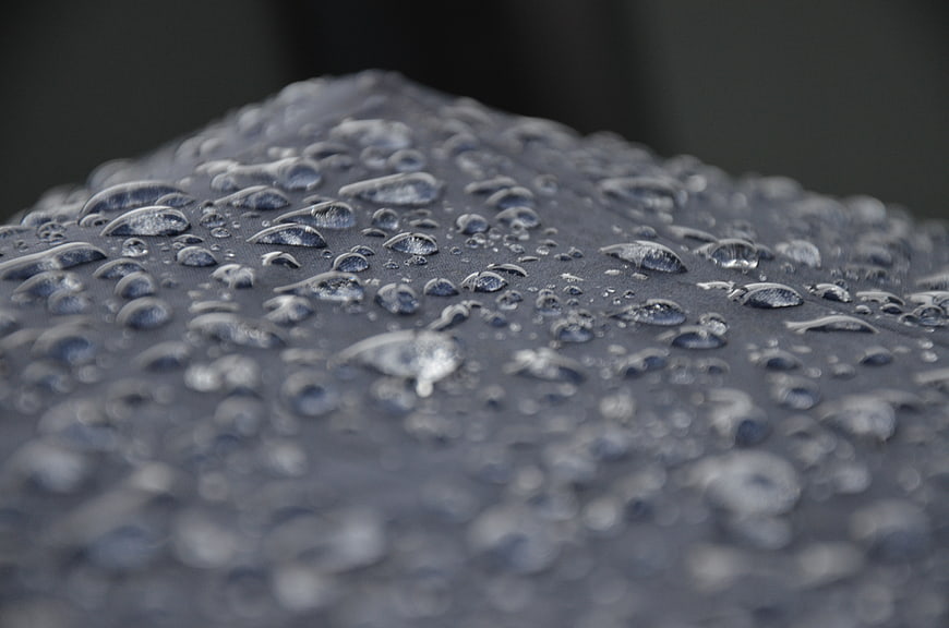 Close-up of water droplets on a dark textured surface