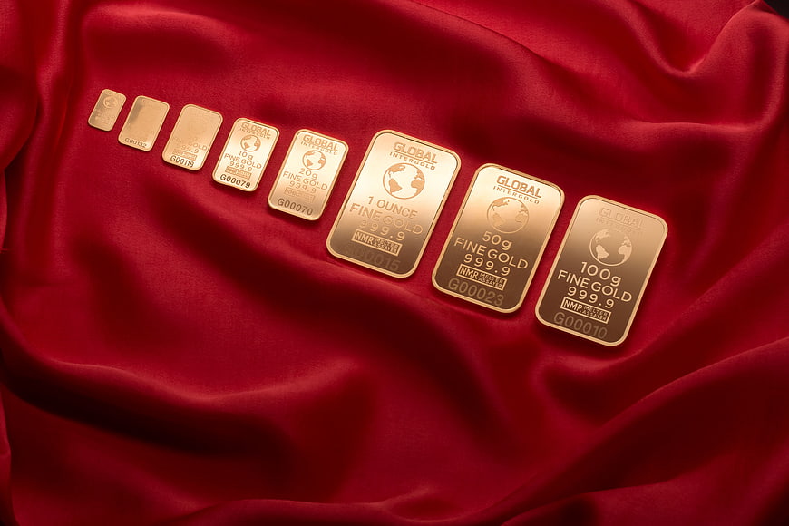 Gold bars on red silk luxury background