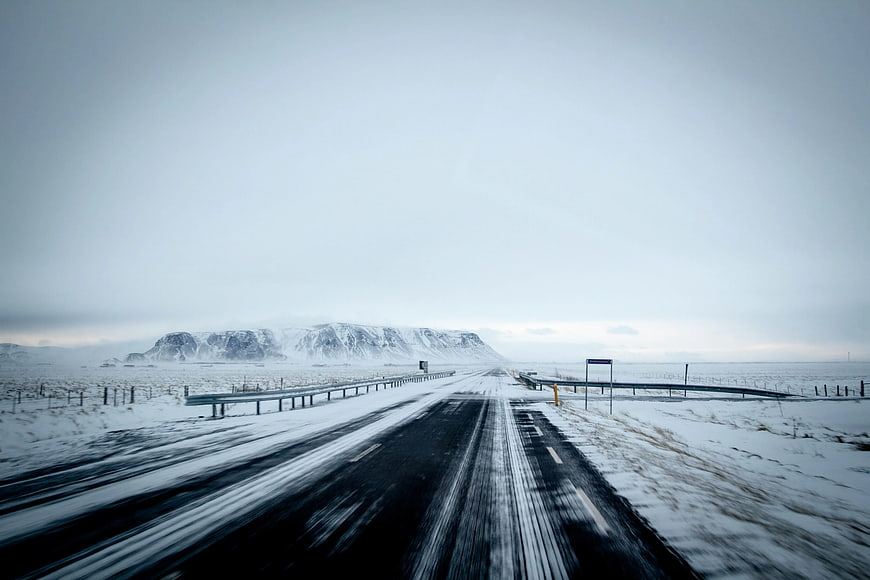 Snowy Winter Road Leading to Distant Mountains