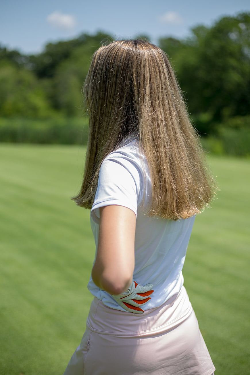 Golfer Woman Holding Back Pain on Green