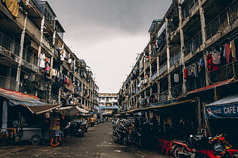 Narrow Urban Street Scene With Old Apartment Buildings And Motorbikes