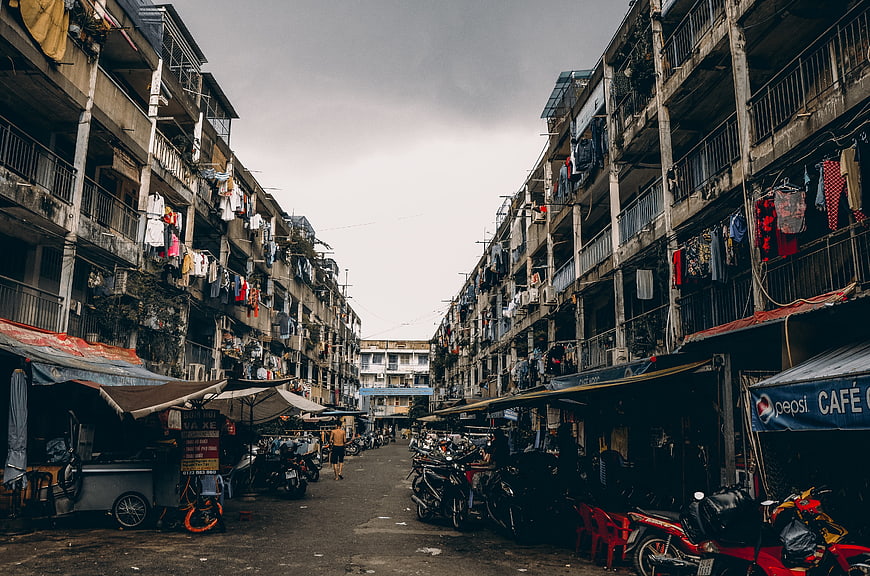 Narrow Urban Street Scene With Old Apartment Buildings And Motorbikes
