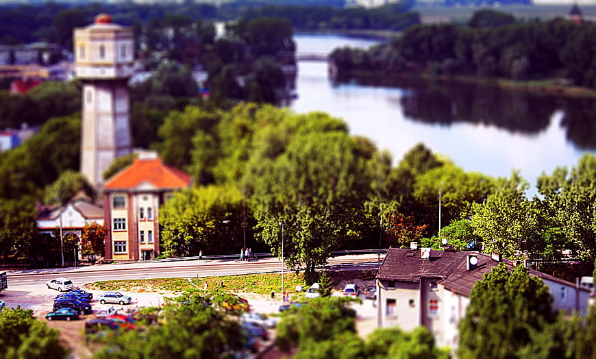 Tilt-shift miniature effect of European town with river and water tower