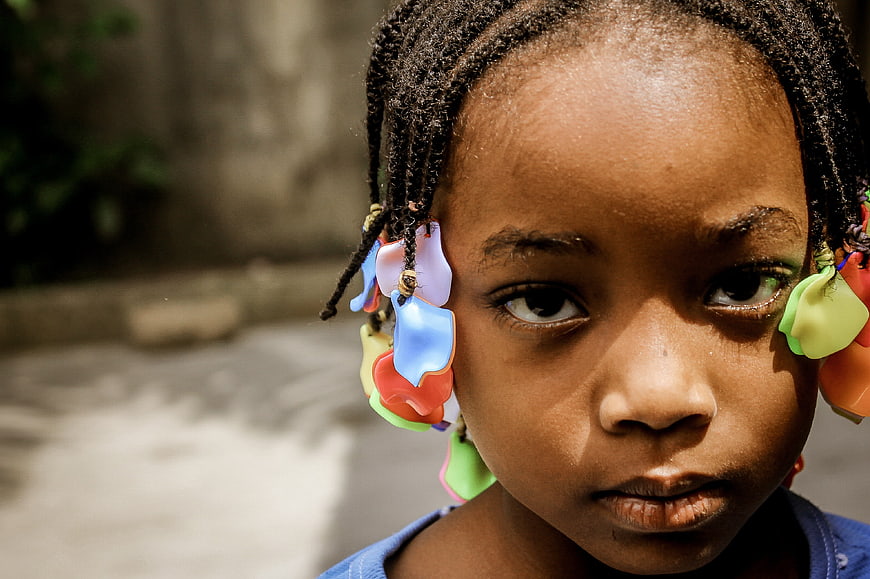 Close-up portrait of young girl with colorful beads in braids