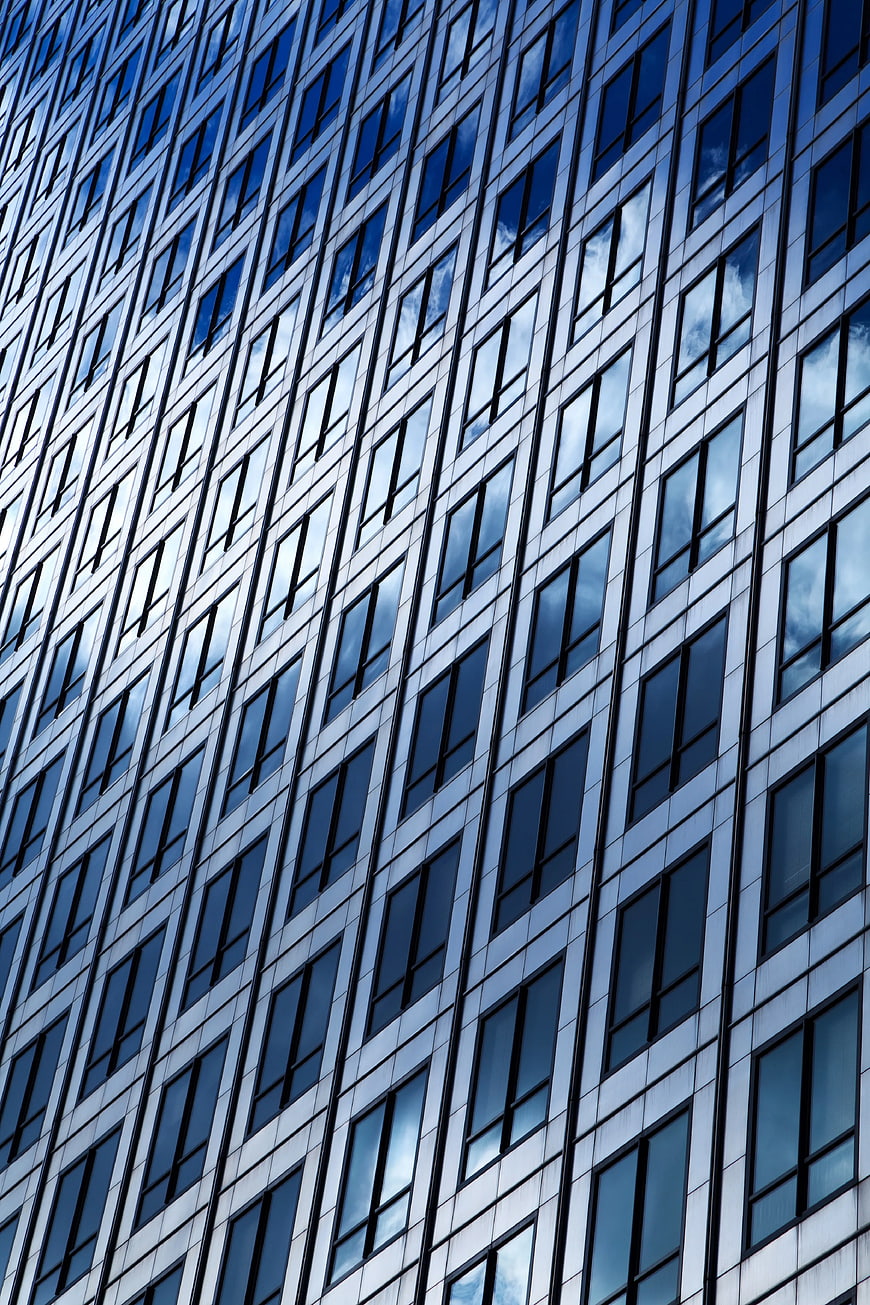 Modern Glass Skyscraper Facade with Blue Sky Reflections
