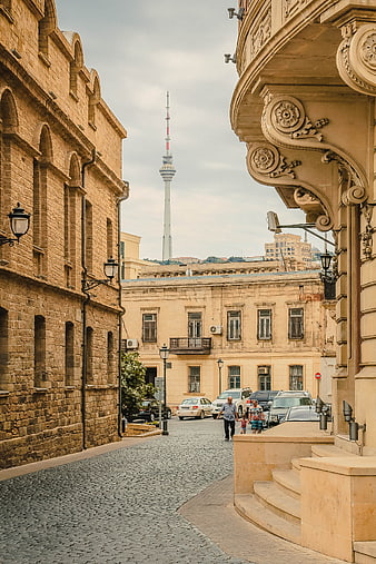 Cobblestone street in Baku with TV tower and historic architecture
