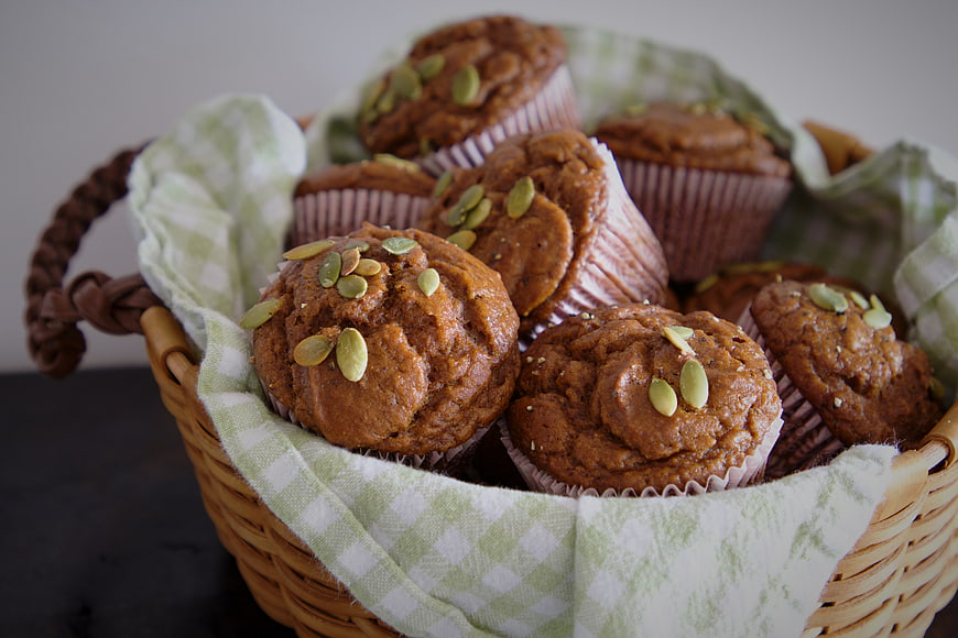 Homemade pumpkin muffins with seeds in a wicker basket