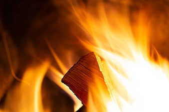 Close-up of burning wood log with bright orange flames
