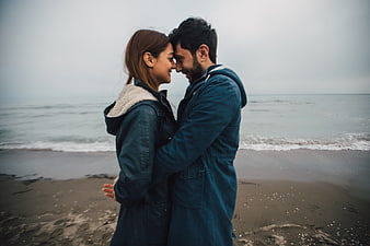 Romantic couple embracing on a misty beach shore