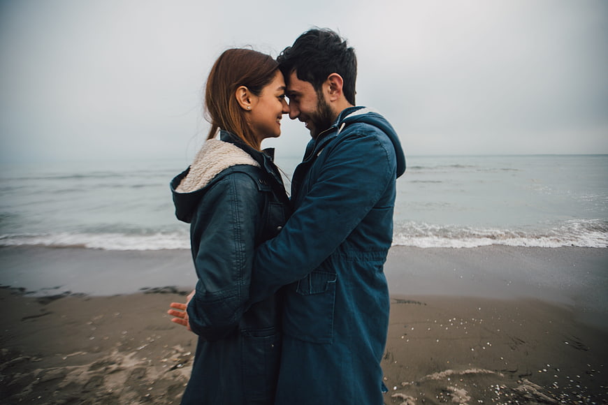 Romantic couple embracing on a misty beach shore