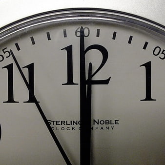 Close-up of analog clock face showing midnight