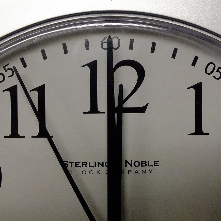Close-up of analog clock face showing midnight
