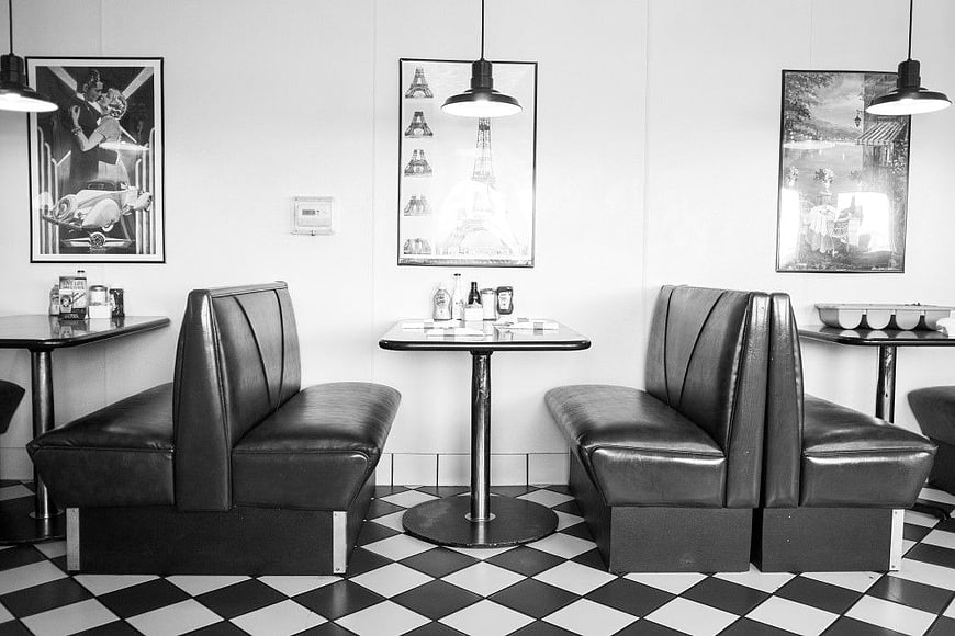 Retro Diner Interior with Black Leather Booths and Checkered Floor