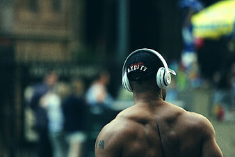 Shirtless Man with Headphones and Cap from Behind